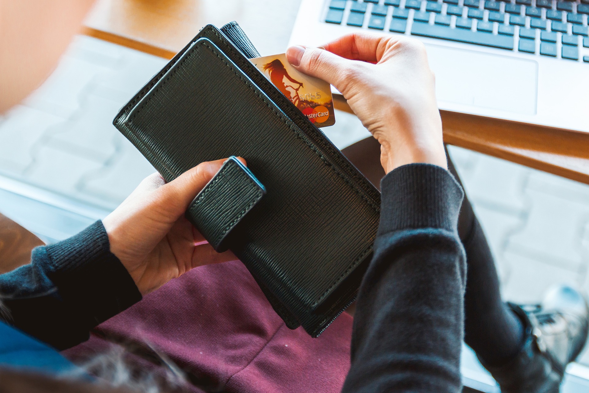 Customer removing credit card from their wallet ready to make an online purchase